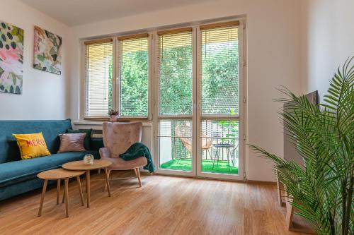a living room with a blue couch and a table at Apartament HoliStay in Oświęcim