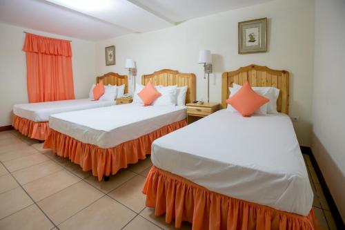 a room with two beds with orange and white at Hotel La Estacion in Granada