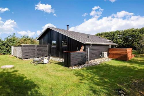 a black house with a grassy yard in front of it at 136-Snedsted-Lykkens-Hab-23 in Snedsted