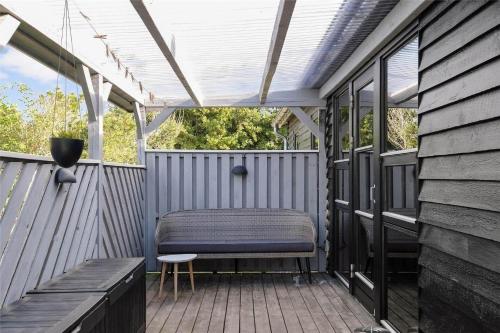 a screened porch with a bench and a pergola at 136-Snedsted-Lykkens-Hab-23 in Snedsted