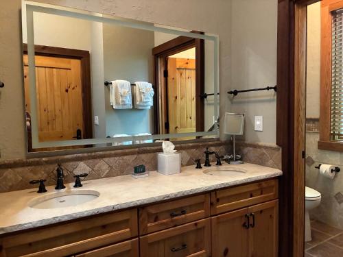 a bathroom with two sinks and a large mirror at Stonewater Cove in Shell Knob