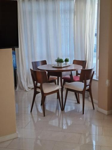 a dining room table and chairs and a window at Apartamento no Centro de Brusque/SC in Brusque