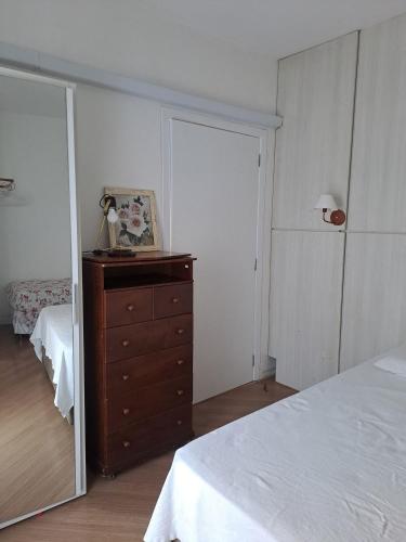 a bedroom with a bed and a dresser and a mirror at Apartamento no Centro de Brusque/SC in Brusque
