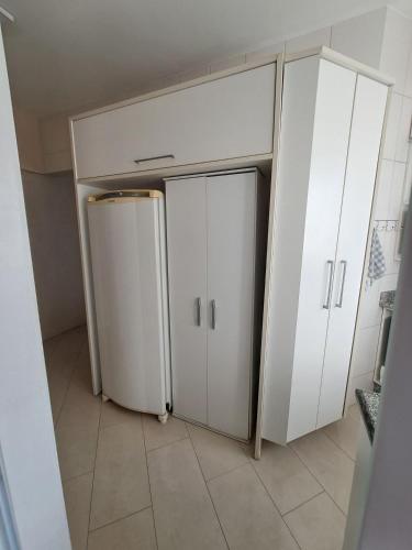 a room with two white cabinets and a refrigerator at Apartamento no Centro de Brusque/SC in Brusque