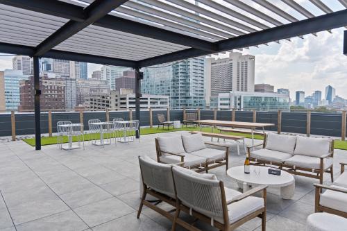 un patio en la azotea con mesas y sillas y un perfil urbano en Sosuite at The Onyx - Museum District, en Filadelfia