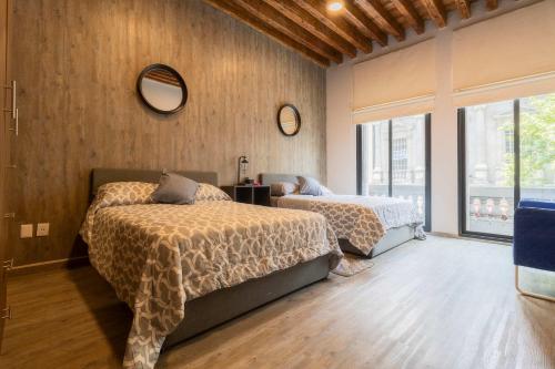 a bedroom with two beds and a mirror on the wall at 105 Centrico Zocalo apt 2Bdrm 2bath AC Rooftop in Mexico City