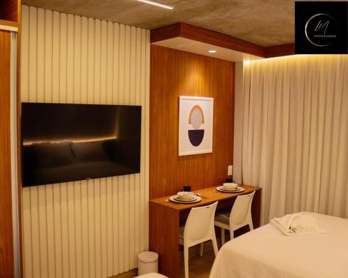 a hotel room with a table and a television at LM Setai Yacht Cabo Branco in Tambaú