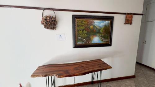 a painting hanging on a wall with a wooden bench at Sapphire Main 1 At 54 in Windhoek