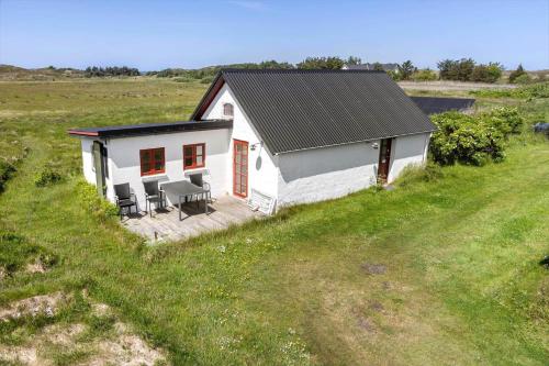 a small white house with a deck in a field at 957-Thisted-Hvidbakken-33-Lille-hus in Torsted