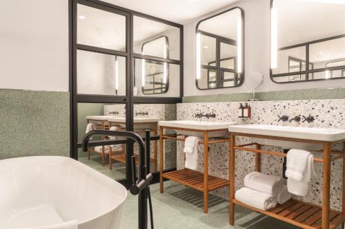 a bathroom with two sinks and two mirrors at Hotel Indigo Lima Miraflores by IHG in Lima
