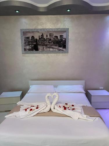 a bed with white sheets and red roses on it at Casa Gena in Favaro Veneto
