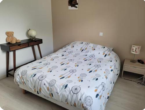 un lit dans une chambre avec un ours en peluche sur une table dans l'établissement La Saga, à Quintin