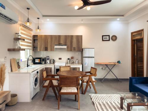 a kitchen with a table and chairs in a room at Twin Villa Zulia by Zanzibar Stays - Private Pool Villa Jambiani in Jambiani