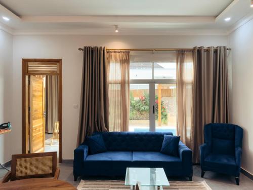 a living room with a blue couch and chairs at Twin Villa Zulia by Zanzibar Stays - Private Pool Villa Jambiani in Jambiani