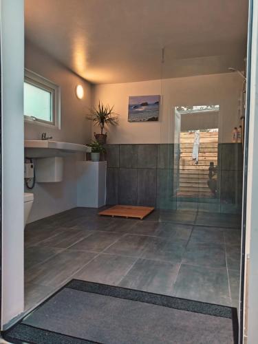 a bathroom with a shower and a tile floor at Bewley Glamping in Wambrook