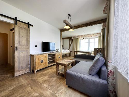 a living room with a couch and a television at Hotel Velká Klajdovka in Brno