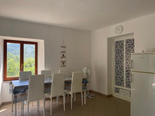 a dining room with a table and chairs and a refrigerator at A 2 Colli dal Mare in Varazze