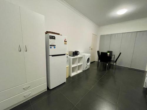 a kitchen with a white refrigerator and a microwave at Private unit in Whitehaven Crescent in Cannonvale