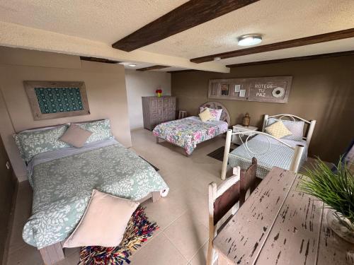 a small room with two beds and a table at Hotel Recreacional Marcelandia Santa Rosa de Cabal in Santa Rosa de Cabal