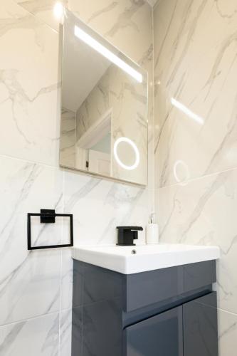 a bathroom with a sink and a mirror at Dolphin Retreat close to Beaches and Harbour in Poole