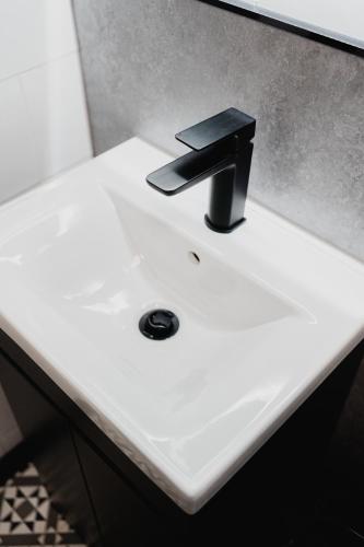 a bathroom sink with a black faucet on it at The Yorkshire Unicorn in Skipton