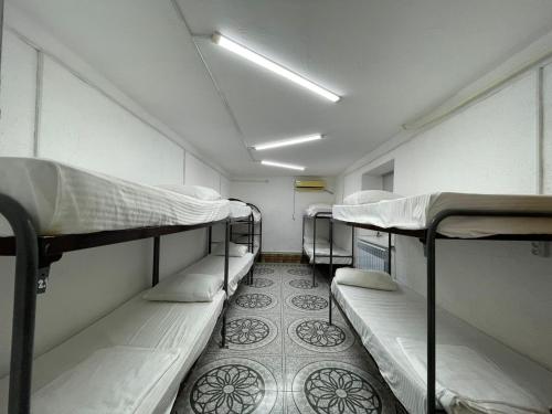a small room with three bunk beds in it at Adeke Hostel in Atyraū