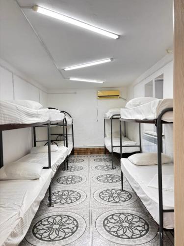 a room with four bunk beds and a carpet at Adeke Hostel in Atyraū