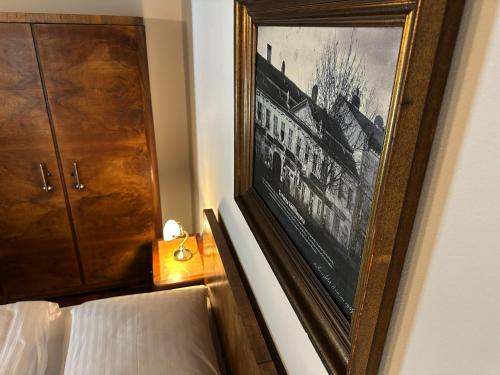 a picture hanging on a wall next to a bed at Hotel Velká Klajdovka in Brno
