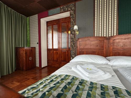 a bedroom with a large bed with a wooden headboard at Hotel Velká Klajdovka in Brno