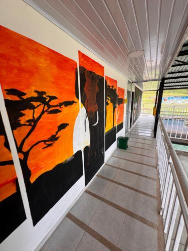 a hallway with paintings on the walls of a building at Hotel Recreacional Marcelandia Santa Rosa de Cabal in Santa Rosa de Cabal