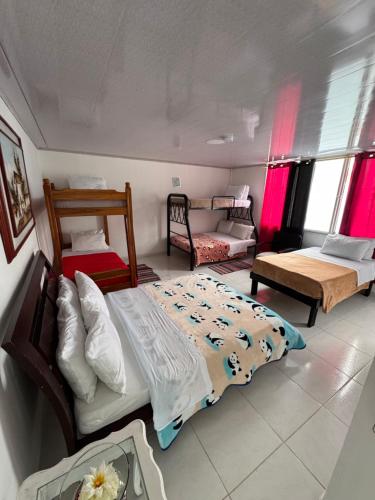 a bedroom with two beds and a couch in it at Hotel Recreacional Marcelandia Santa Rosa de Cabal in Santa Rosa de Cabal