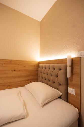 a bedroom with a bed with a light on the wall at Hotel Marlingerhof in Marlengo