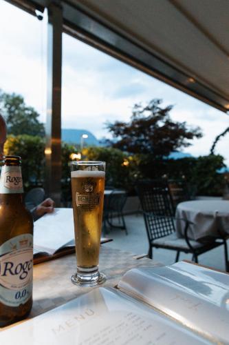 a glass of beer sitting on a table with a book at Hotel Marlingerhof in Marlengo