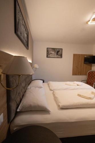 a hotel room with two beds and a lamp at Hotel Marlingerhof in Marlengo