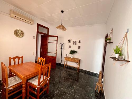 a dining room with a wooden table and chairs at Casa caloret 1r Pl 2 minutos de la playa y del centro in Vinaròs
