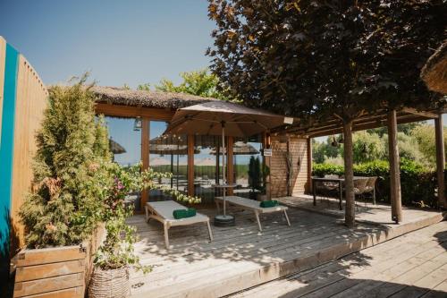 a patio with an umbrella and a table and chairs at Villa Versus Beach in Struga