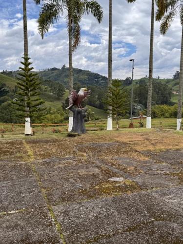 a statue of a woman standing in a park with palm trees at Hotel Recreacional Marcelandia Santa Rosa de Cabal in Santa Rosa de Cabal