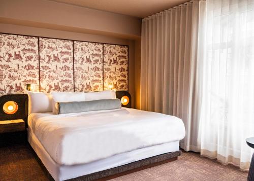 a bedroom with a large white bed and a window at Hôtel Saint-Sulpice in Montréal