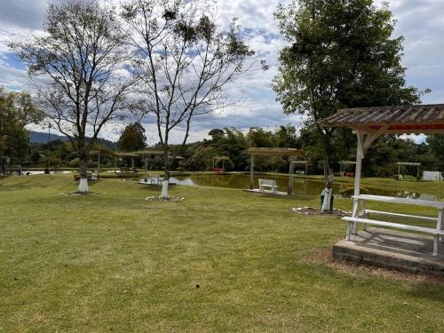 a park with a bench and a gazebo and a pond at Hotel Recreacional Marcelandia Santa Rosa de Cabal in Santa Rosa de Cabal