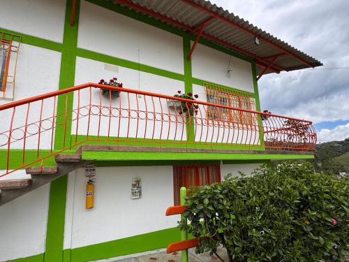 a green and white building with a balcony at Hotel Recreacional Marcelandia Santa Rosa de Cabal in Santa Rosa de Cabal