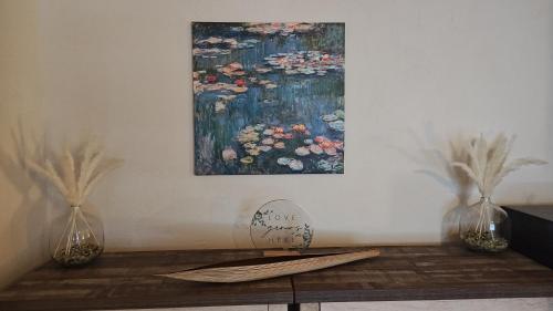 a painting of flowers on a wall next to two vases at Golden House in Santa Clarita