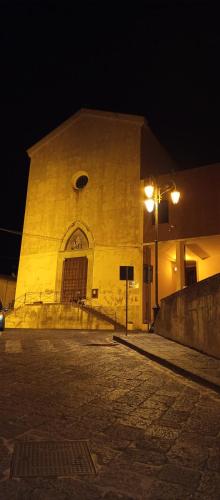 a large yellow building with a street light at night at Casa vacanza Luna in Eboli