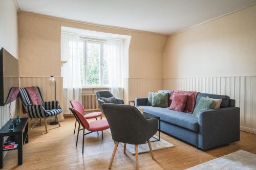 a living room with a blue couch and chairs at Comfort Meets Style in Central Norberg in Norberg