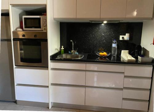 a kitchen with a sink and a microwave at Valença Riverside in Valença
