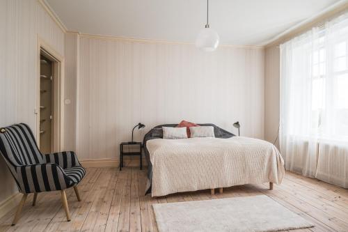 a bedroom with a bed and a chair at Comfort Meets Style in Central Norberg in Norberg