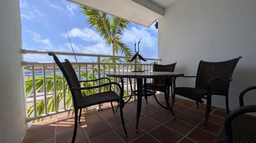 a balcony with a table and chairs and a view of the ocean at Bimini Tides in South Bimini