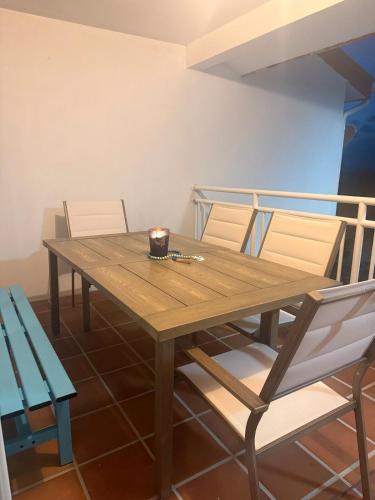 a wooden table with two chairs and a candle on it at Bimini Tides in South Bimini