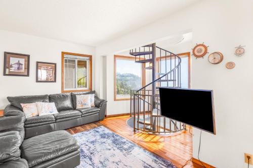 a living room with a couch and a spiral staircase at Seascape in Oceanside in Oceanside