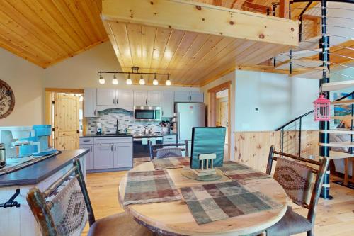 a kitchen and dining room with a wooden table and chairs at Paradox Lake Lookout in Schroon Lake