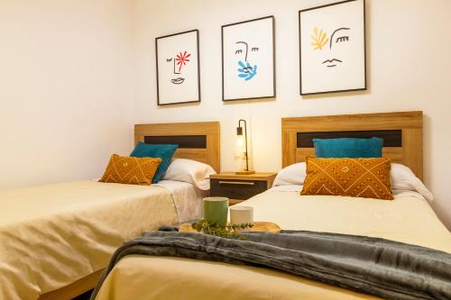 two beds in a room with pictures on the wall at Dream Costa Blanca Luxury Apartment in Torrevieja